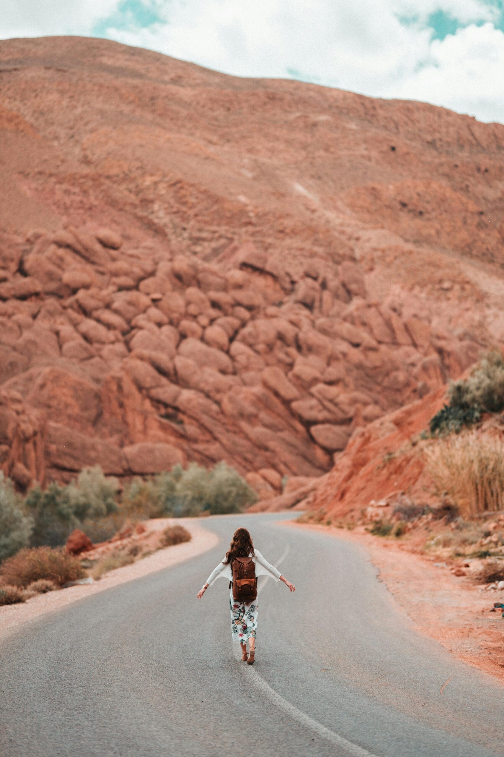 Pexels taryn elliott: photo of woman in skirt walking down middle of road in the desert